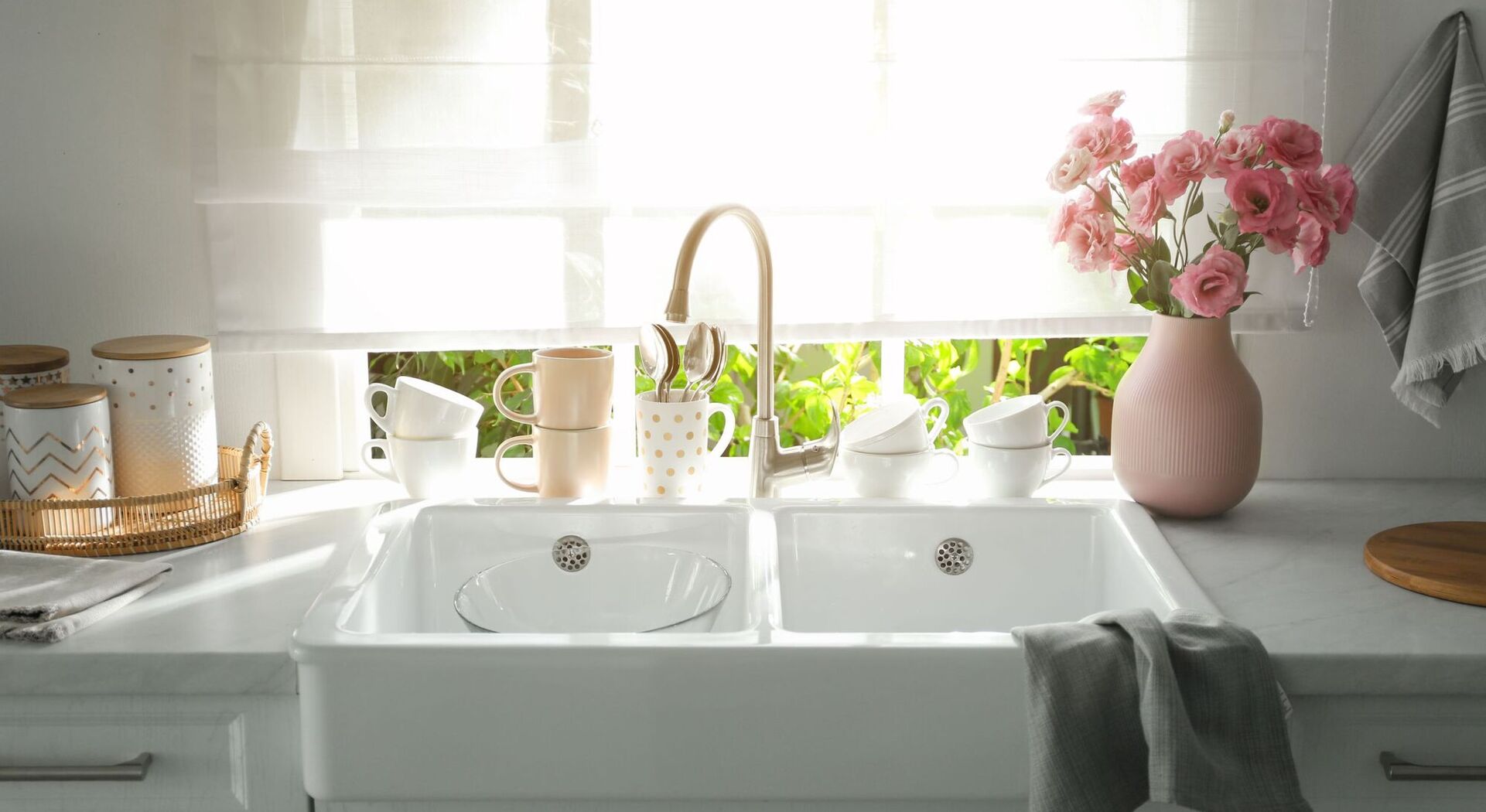 Kitchen window with pink flowers in a vase